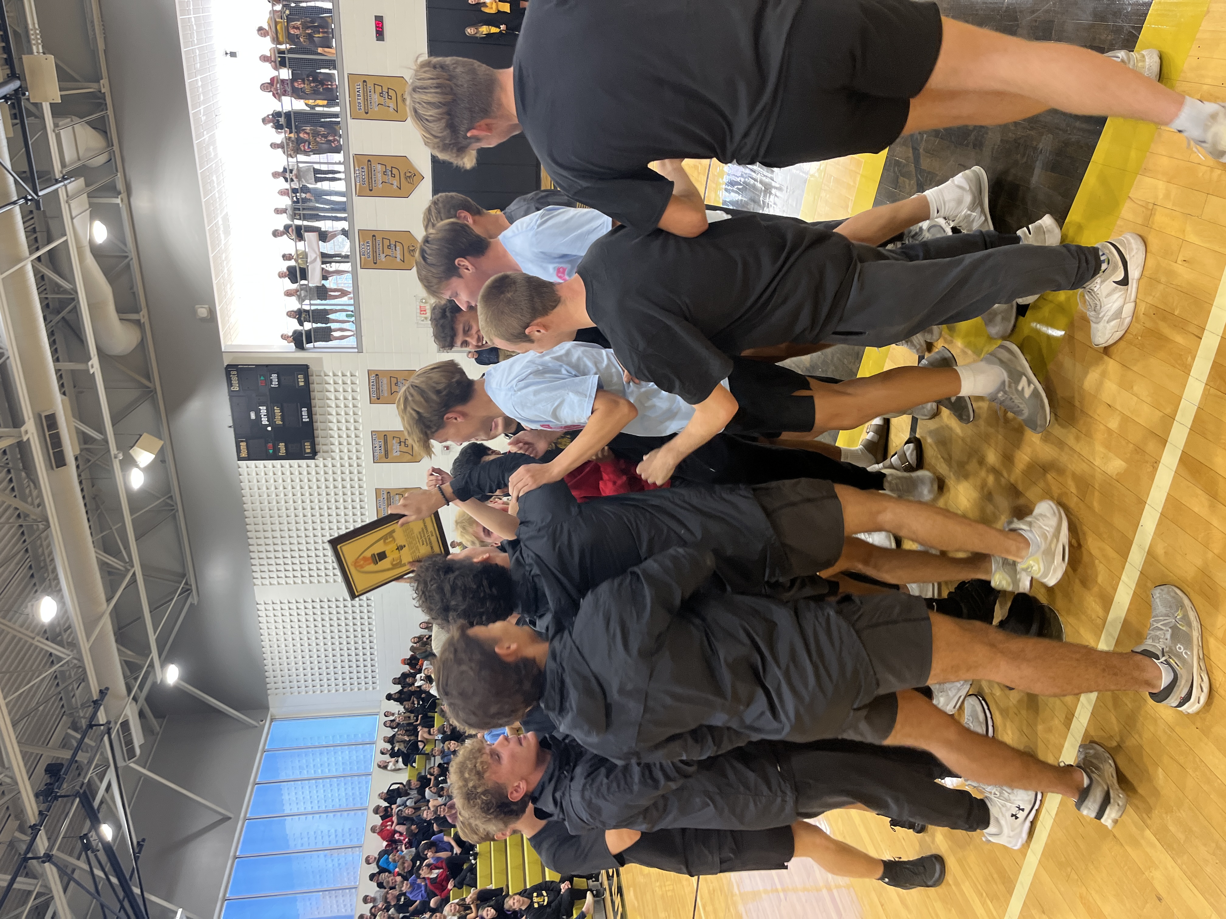 Boys soccer celebrating with their conference championship plaque
