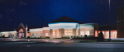 A well-lit building at night, showcasing a modern architectural design with a prominent entrance and surrounding landscaping.