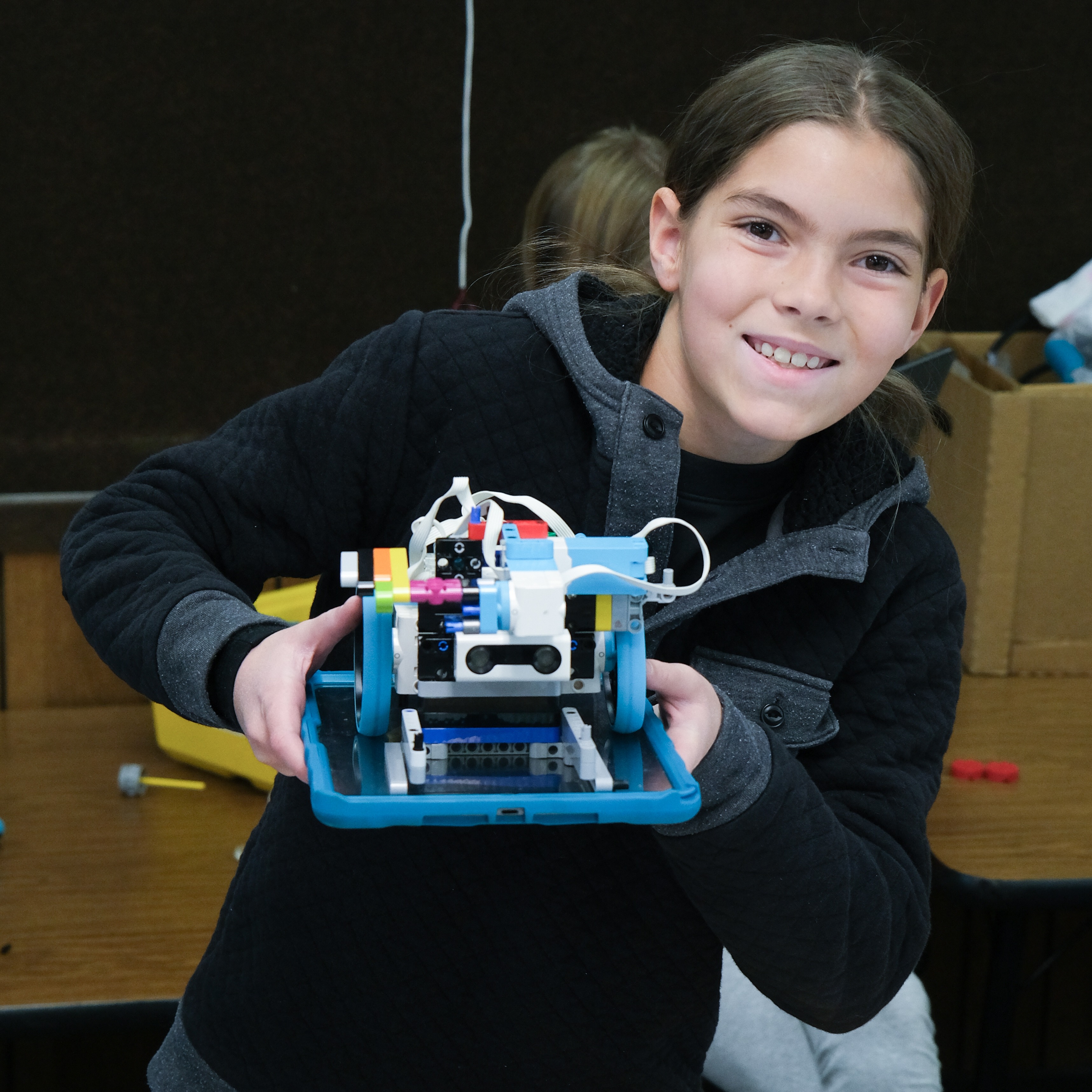 a student hold her robotics project