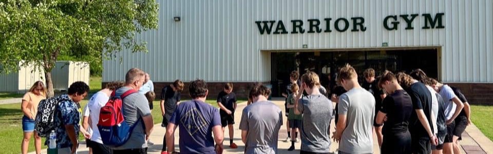 High School Basketball Team praying in a circle