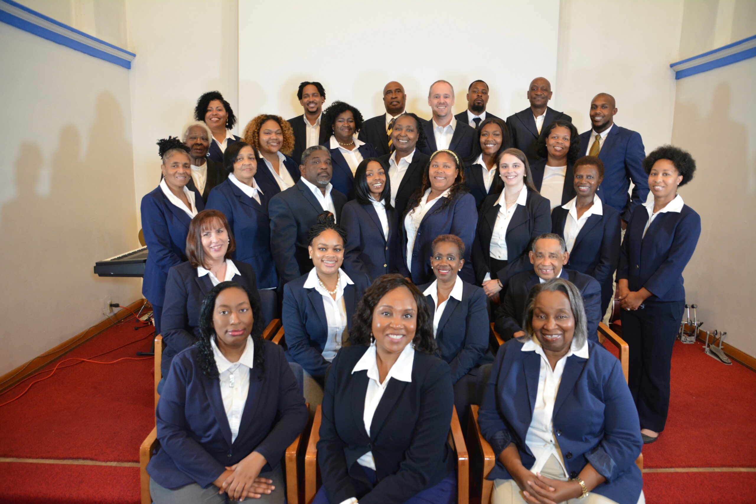 A group of Black individuals dressed in formal suits and ties, standing together with confident expressions.
