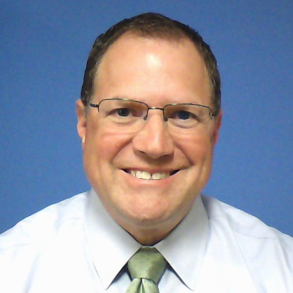 A smiling man with blue background