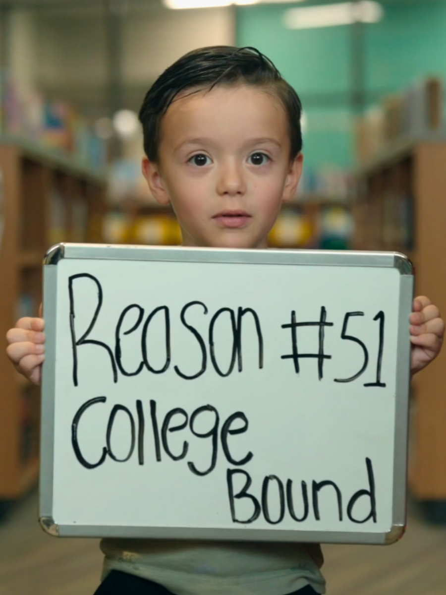 Young male student holding sign that says Reason #51 College Bound