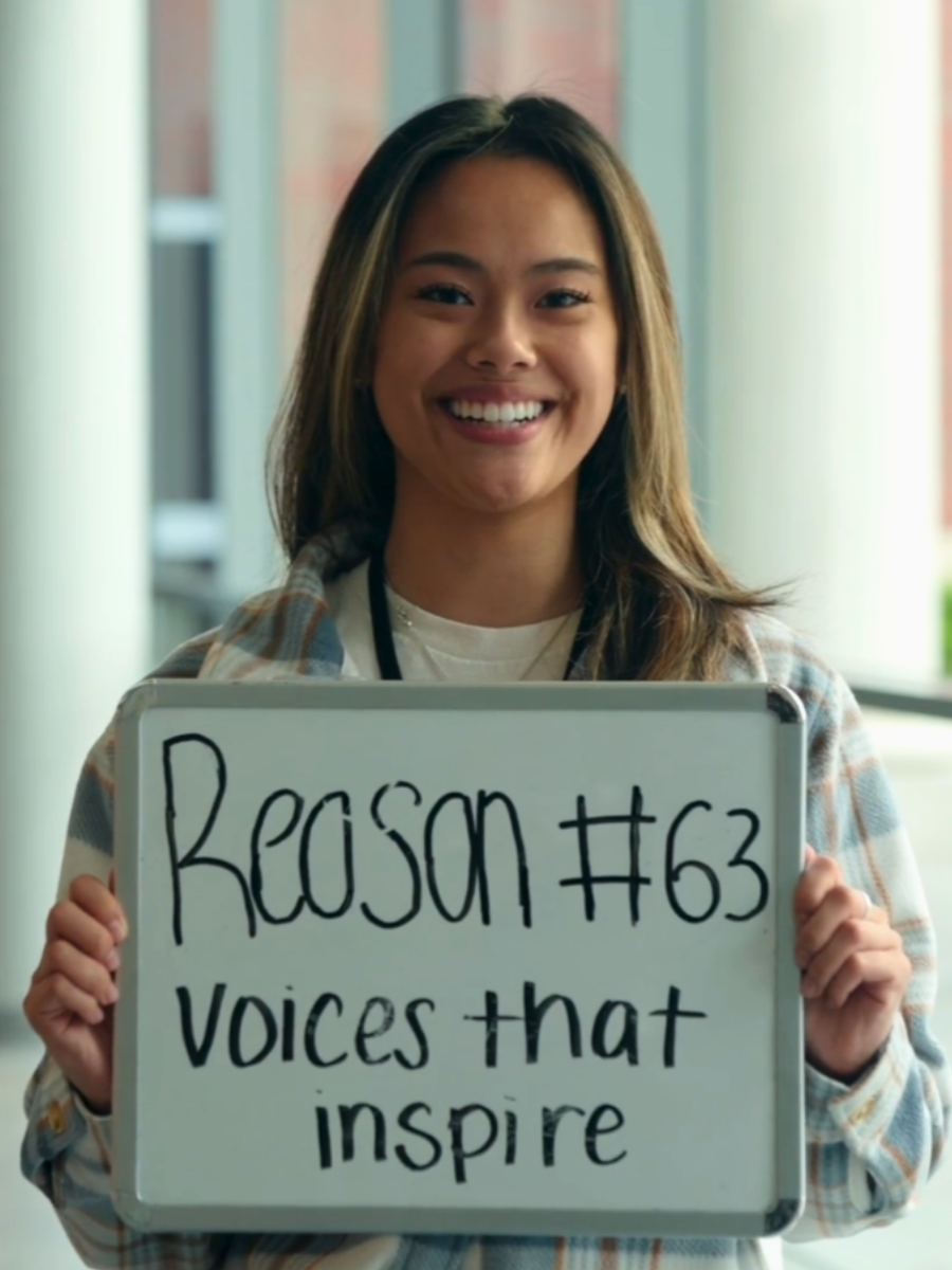 Female student holding sign that says Reason #63 Voices that inspire