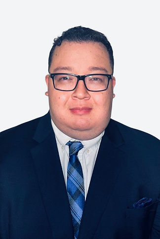 A man wearing glasses and a suit, with a blue tie, poses for a professional headshot against a plain white background.