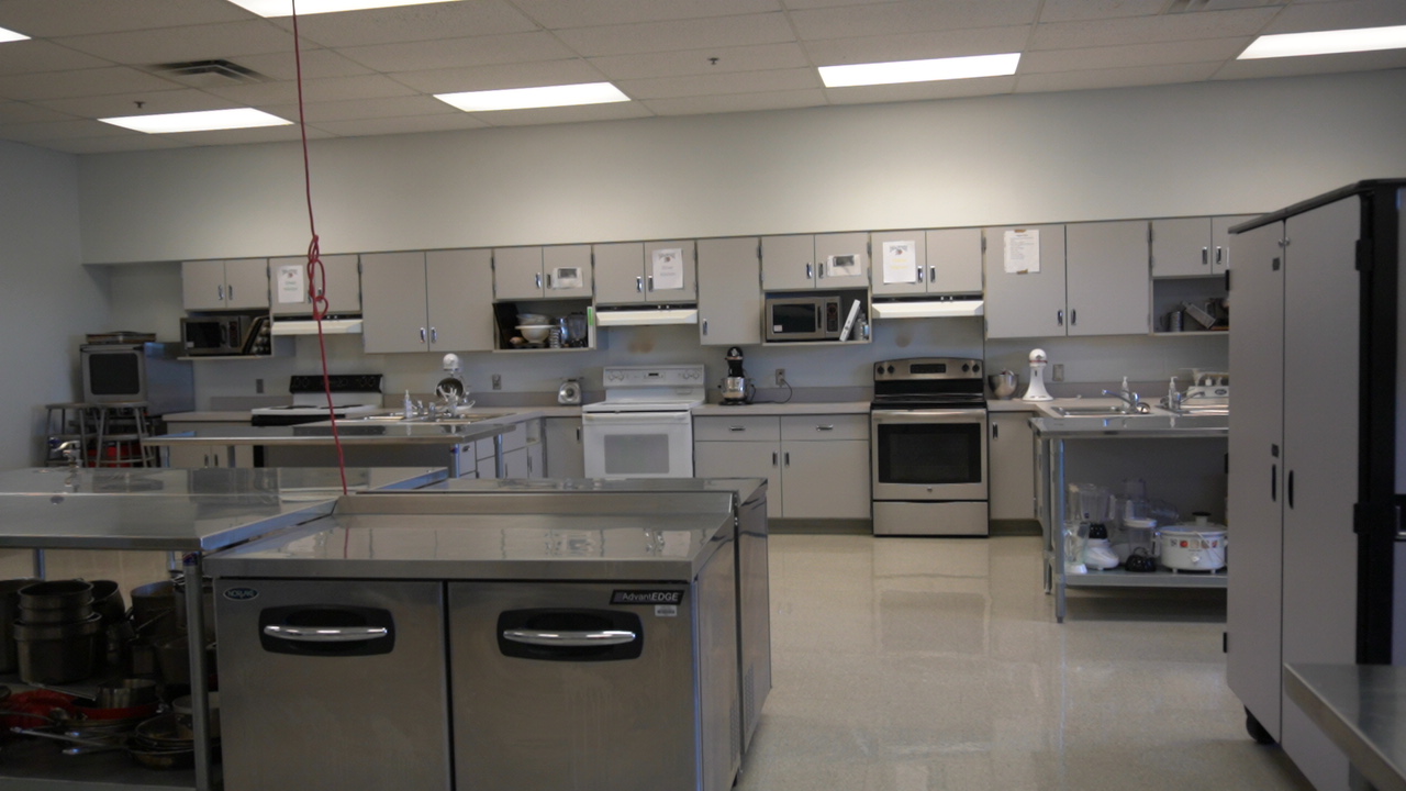 A spacious, well-equipped kitchen featuring stainless steel appliances, countertops, and cabinets, with a clean and organized layout.