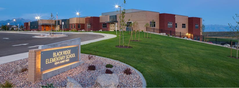 elementary school building behind the sign light up at dusk