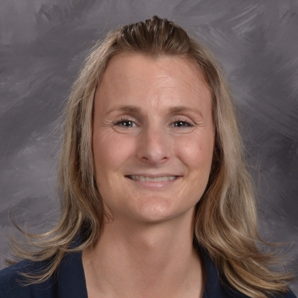 a smiling woman with blonde hair against a gray background
