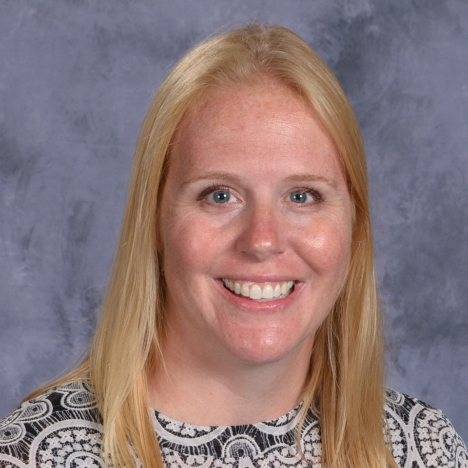 women with short blond hair, black and white shirt on grey background