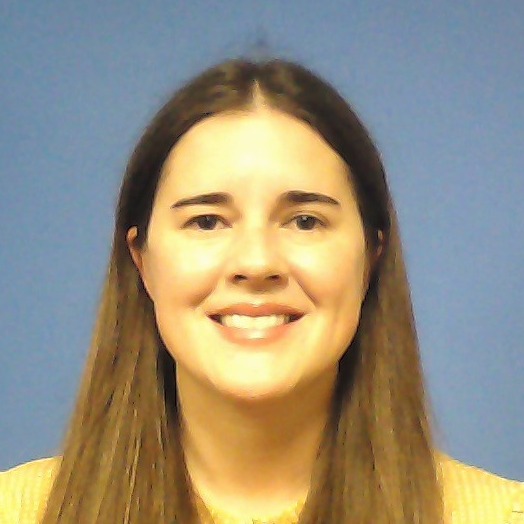 Woman smiling with long brown hair on a blue background