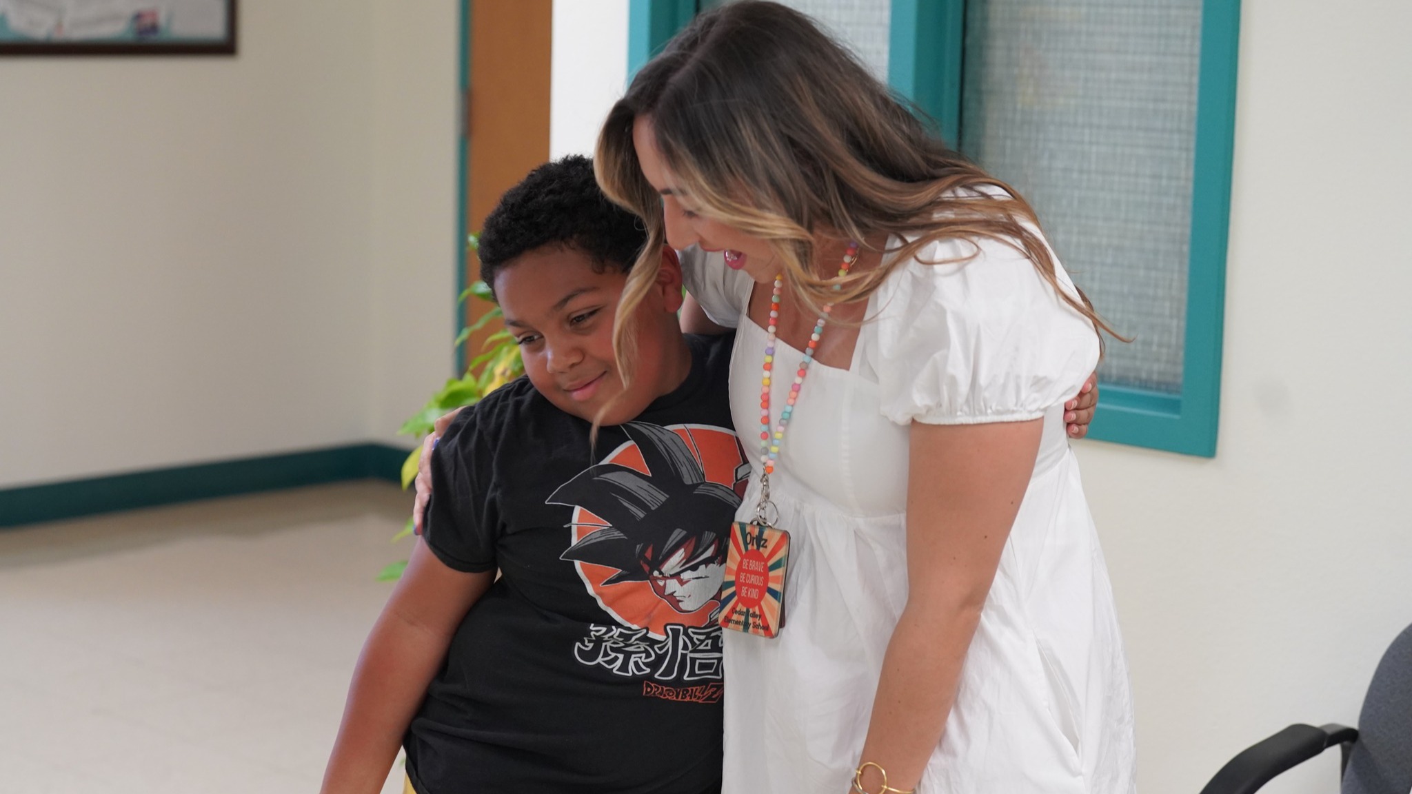 teacher hugging a smiling student