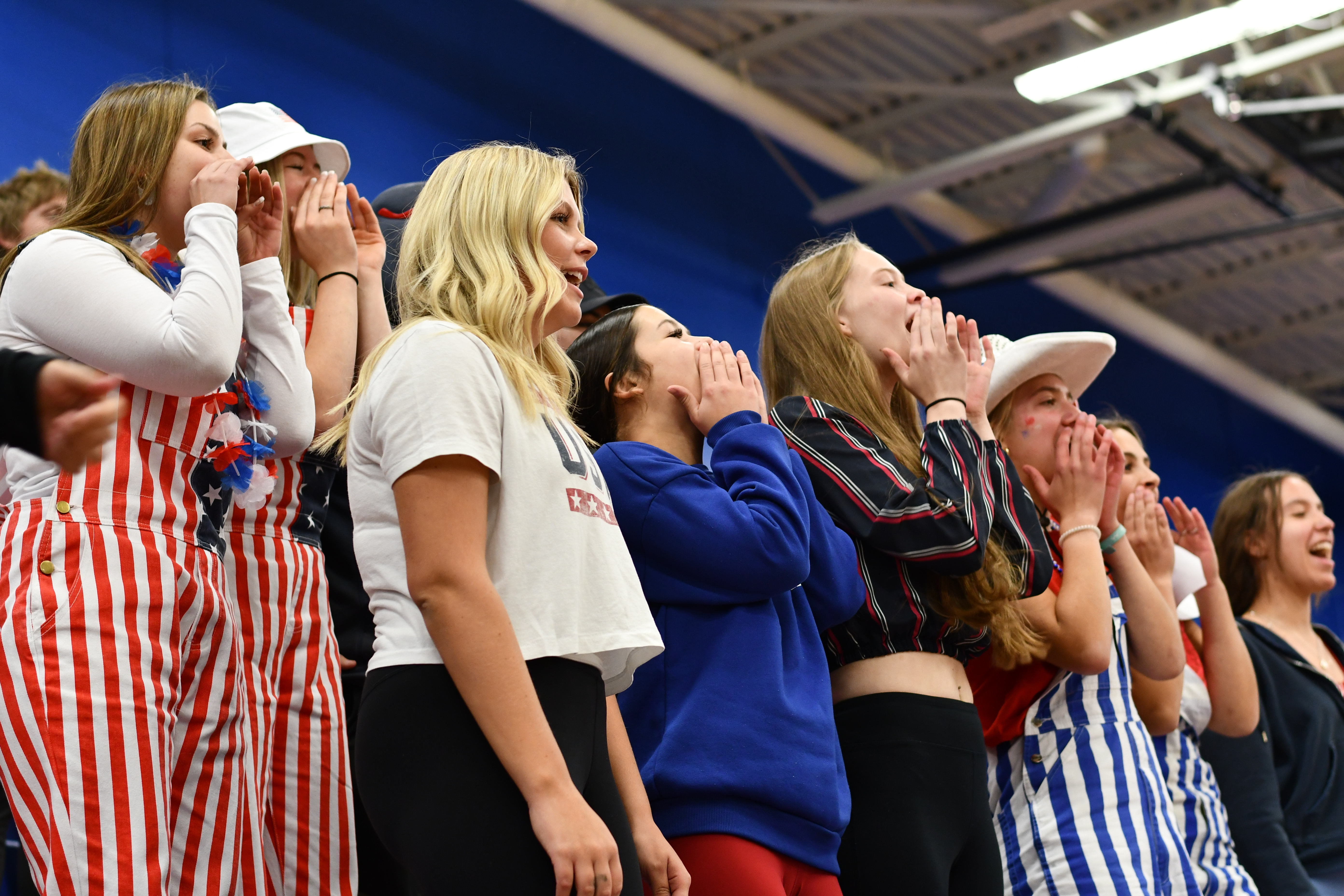 Red, White and Blue theme for the Volleyball game.  High School fans cheering. 