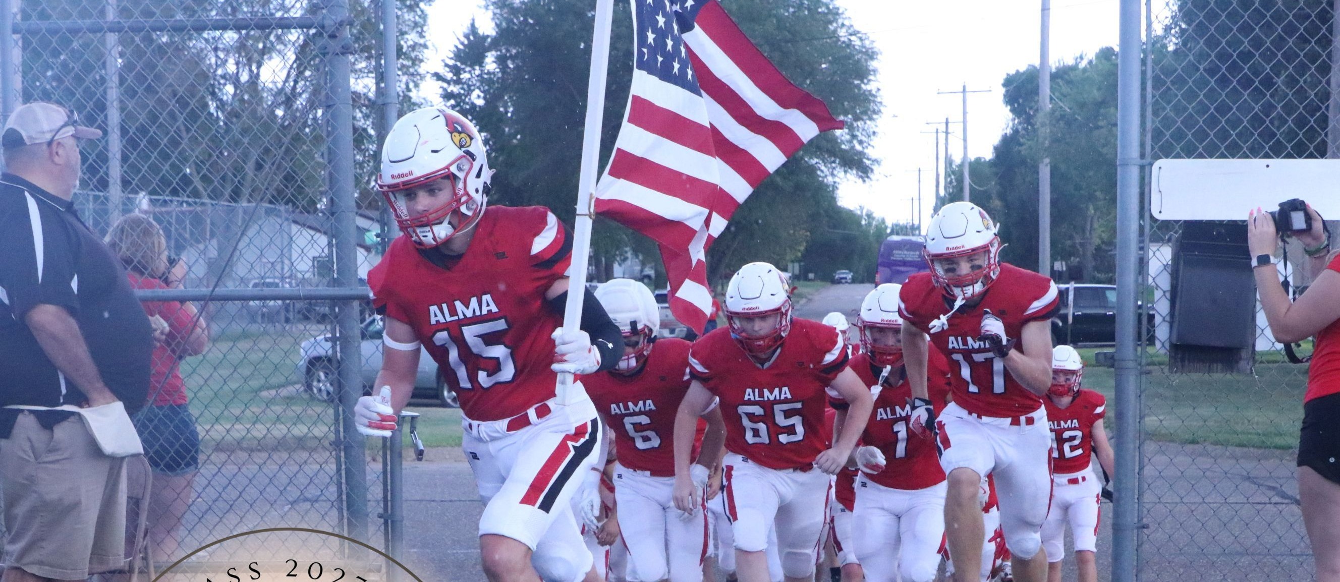 Football Players Carrying In The Flag at Game