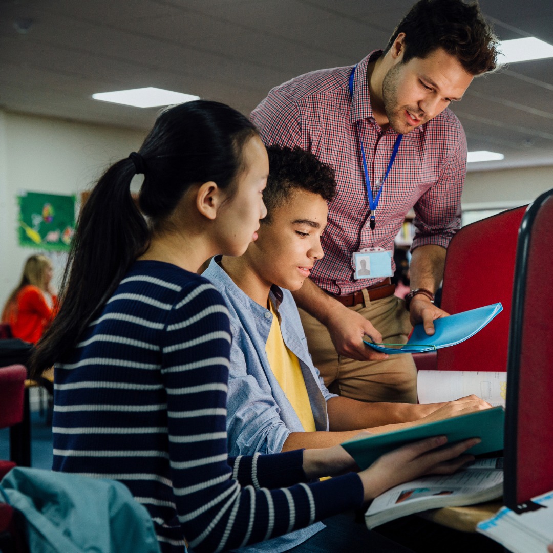 Male teacher speaking to 2 students