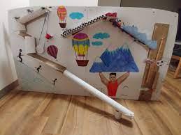 A colorful, interactive board featuring various illustrations including hot air balloons, mountains, and figures in motion, designed for play or educational purposes.