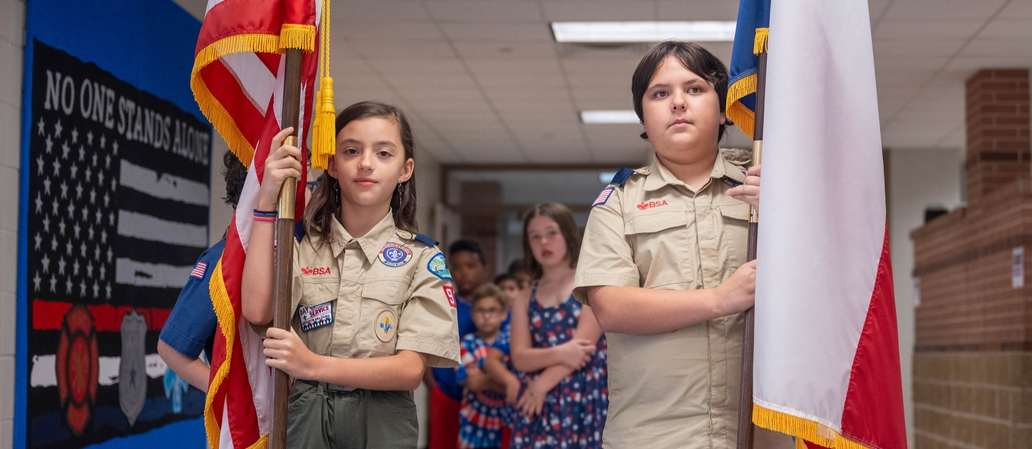 2 scouts stand with flags