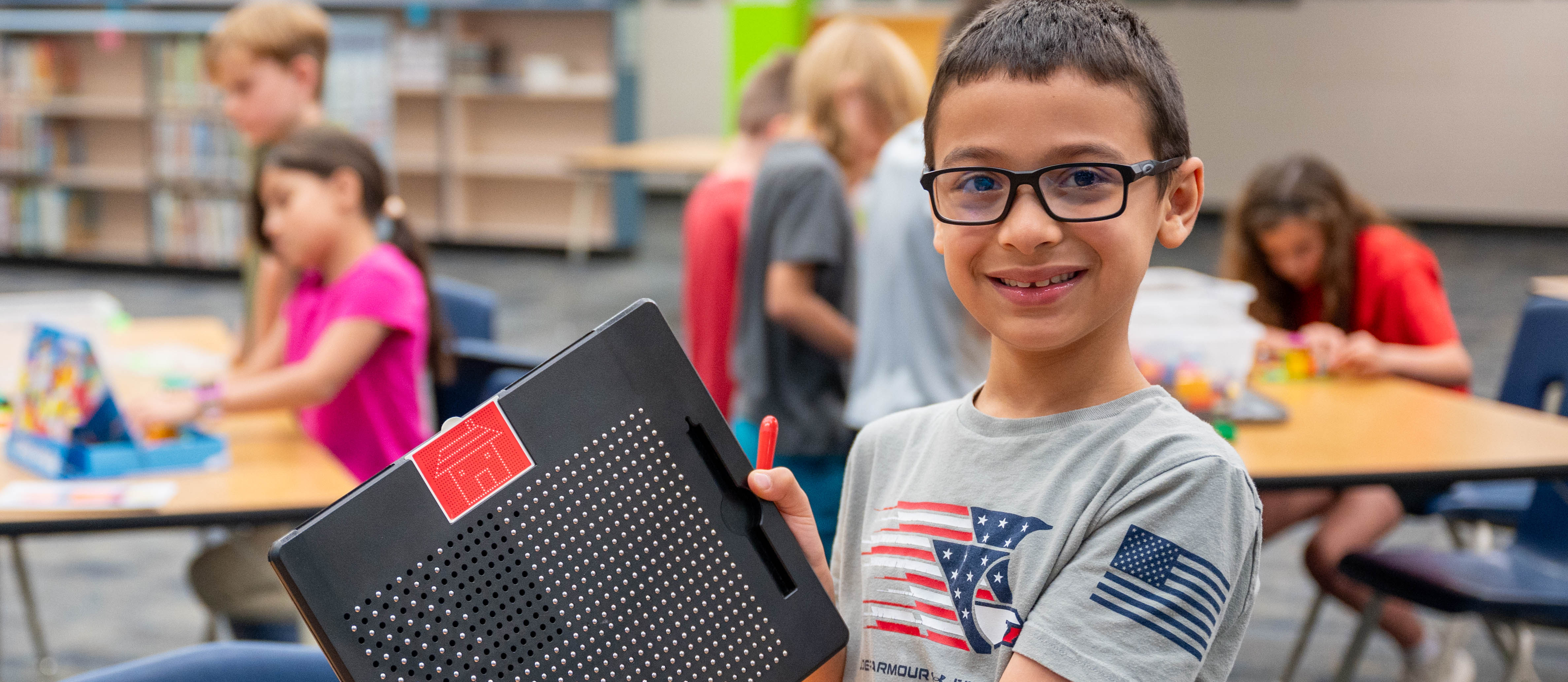 Boy holding his project and smiling