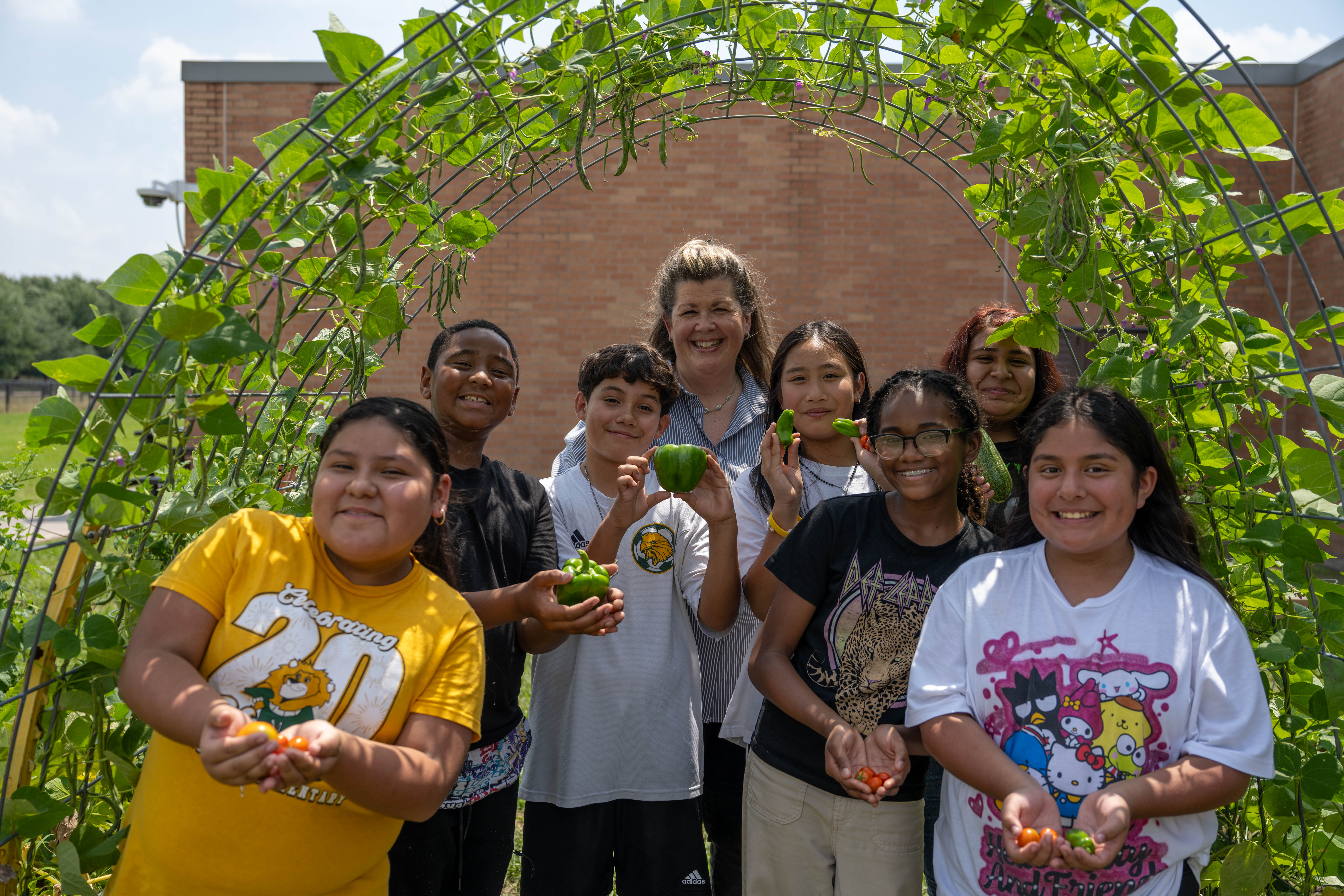Students and teacher pose with plants grown from the McDougle garden.