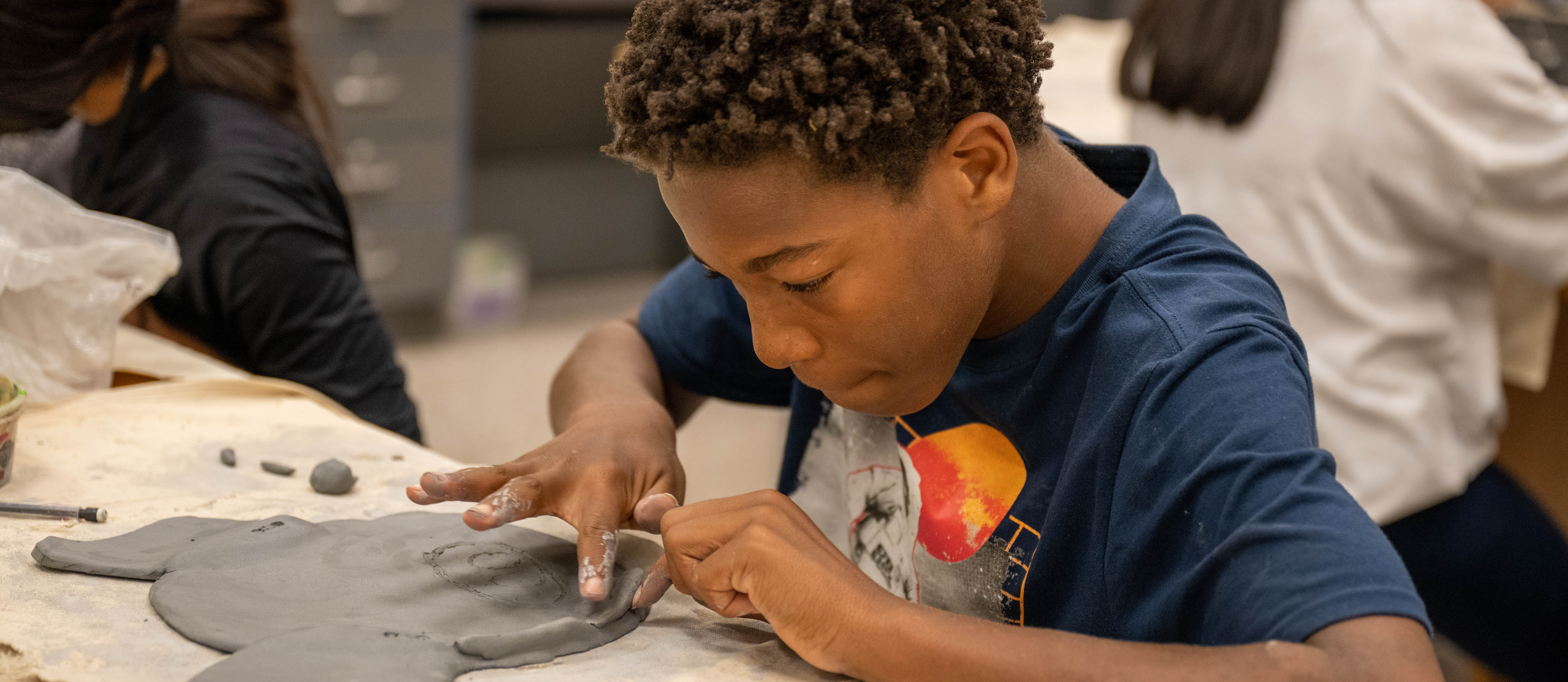boy sculpting with clay