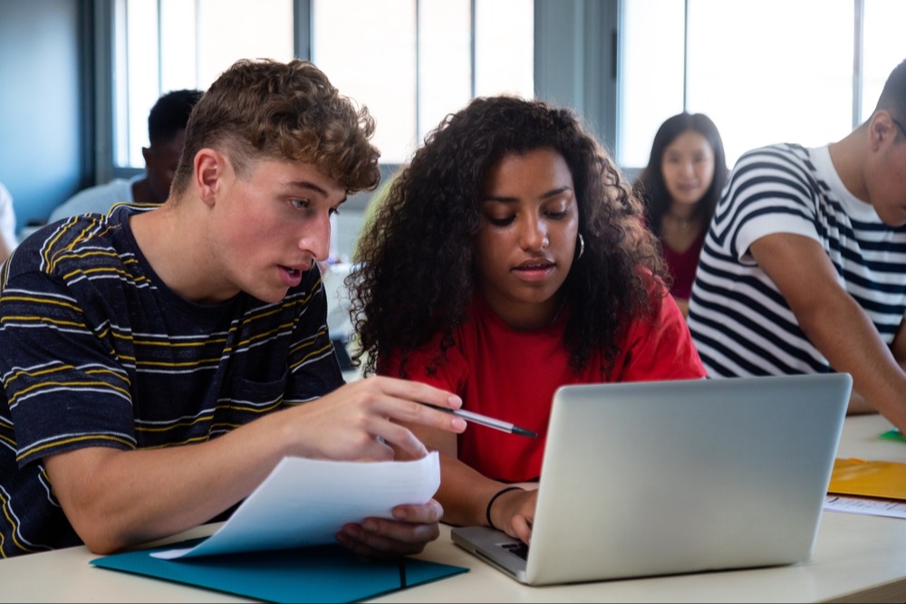 students working together in front of a laptop