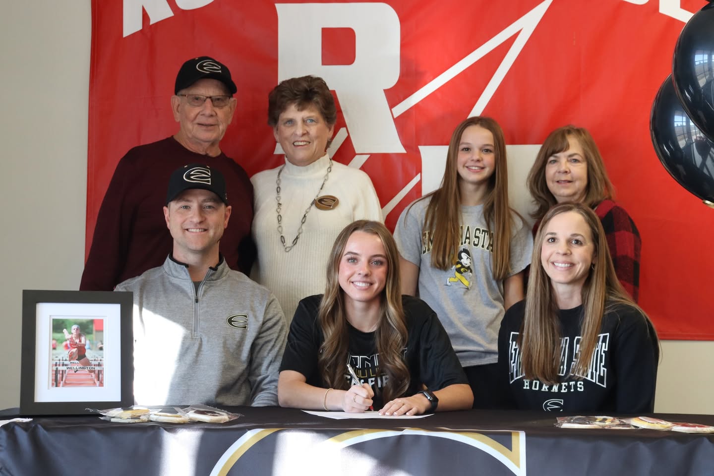 Ava with family as she signs her commitment document.