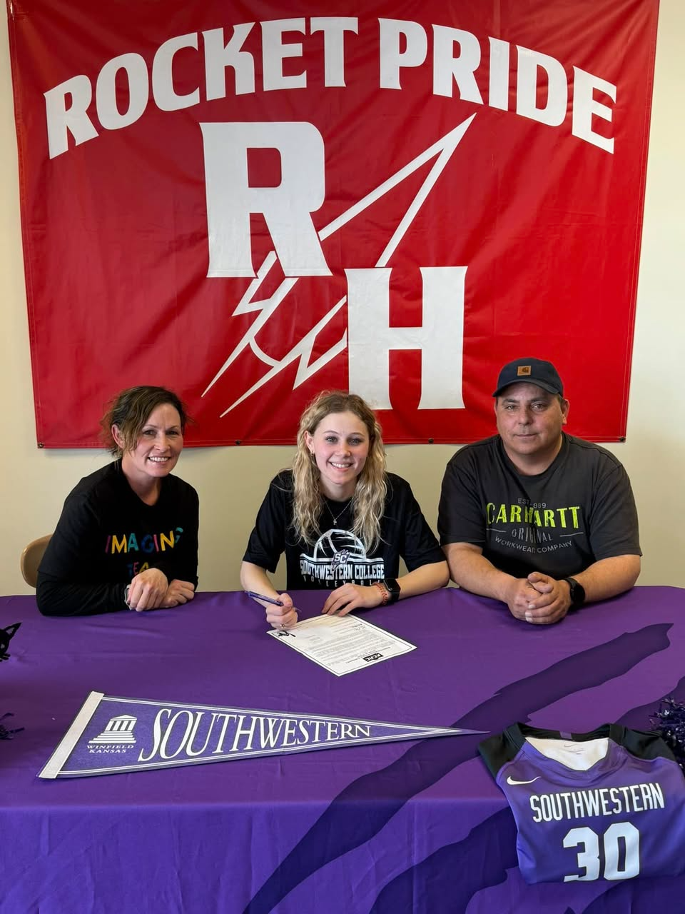 Emily signs her commitment paperwork.
