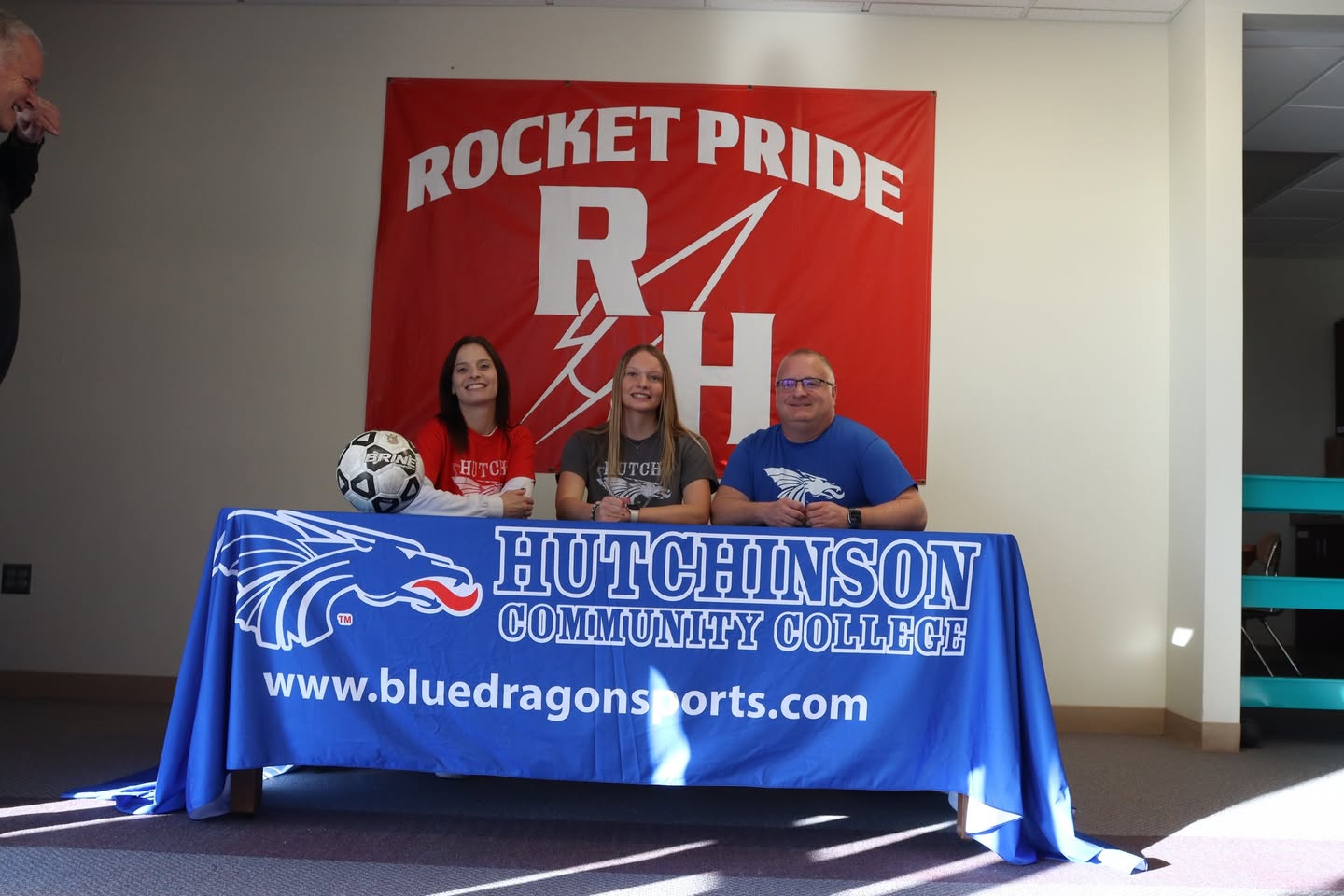 Nevaeh signing her paperwork with family.