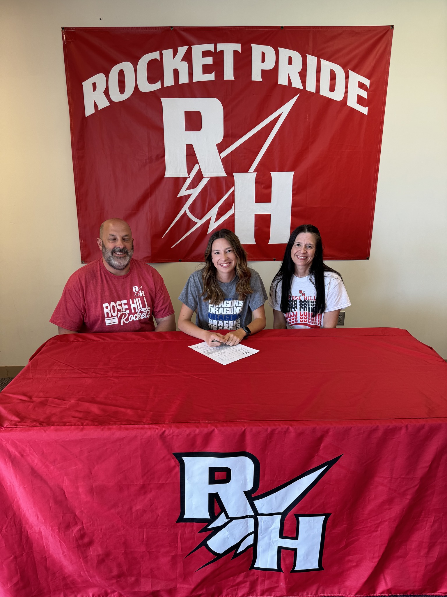 Kimberlin signs her commitment next to her parents.