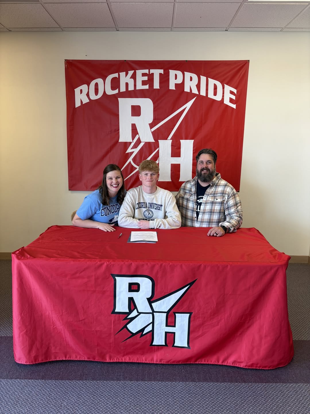 Trayton Allison-Hill signs his commitment with family.