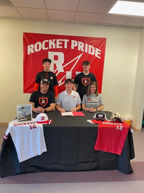 Colten signs surrounded by family.