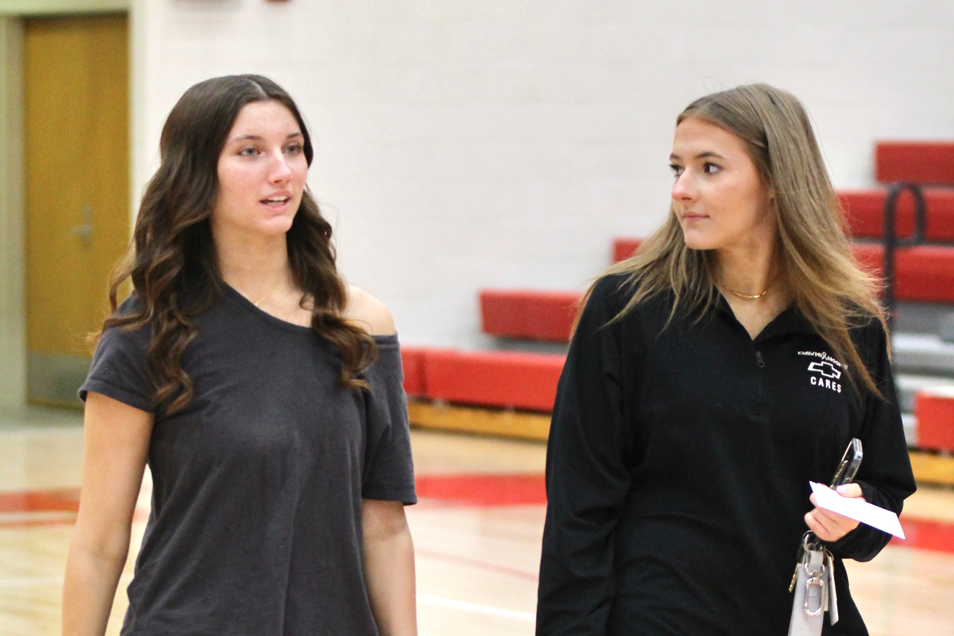 Celia and friend walk into graduation.