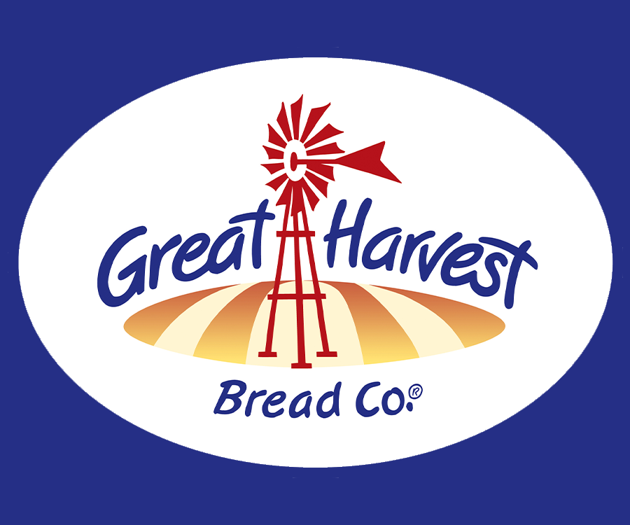 A logo featuring the text 'Great Harvest Bread Co.' with a windmill and a stylized wheat field in the background, set against a blue backdrop.