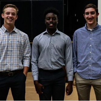 three male students smiling