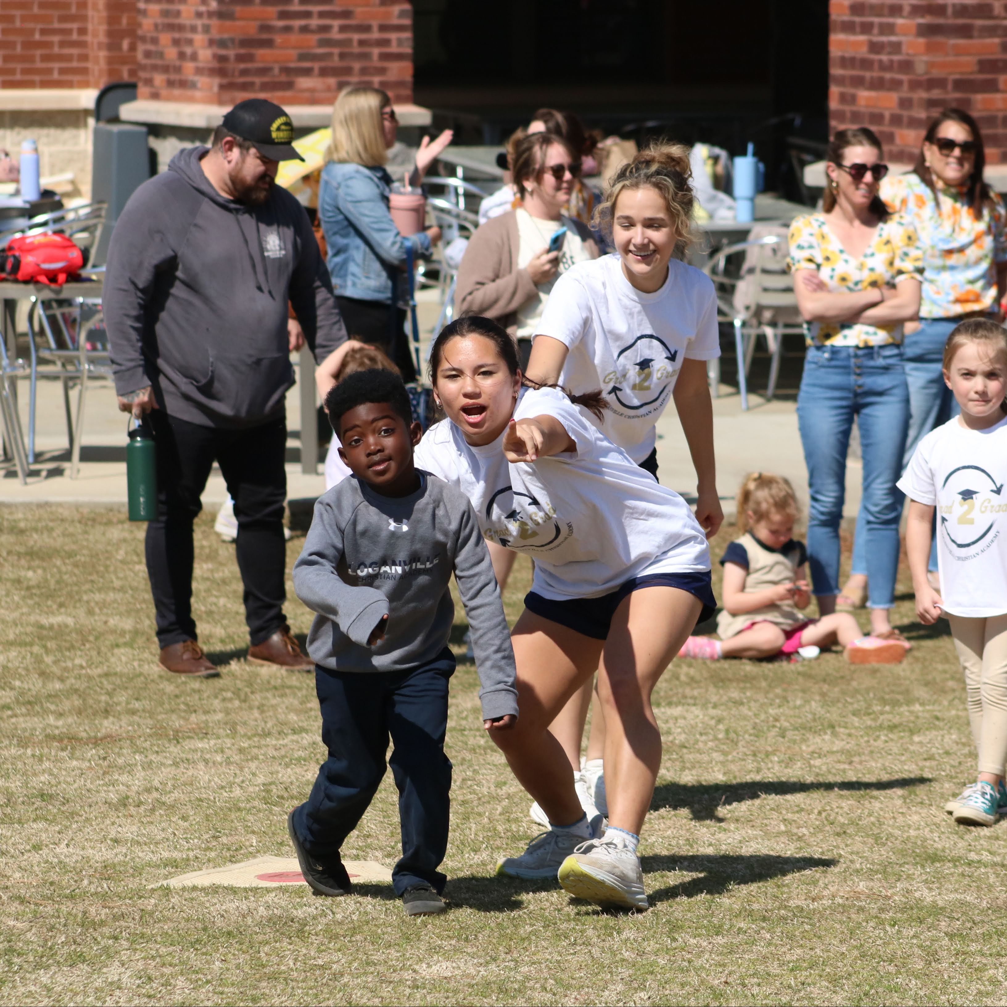 older student helping younger student on the field playing games