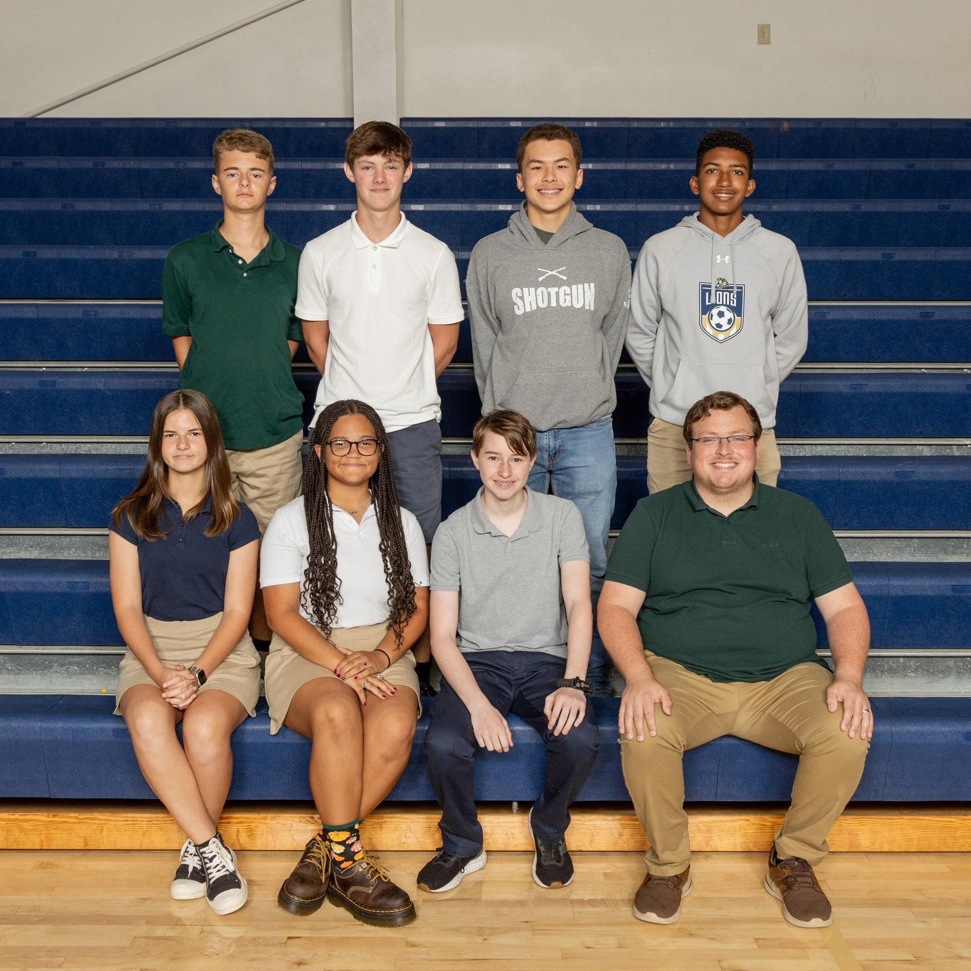 group of students sitting on bleachers and smiling