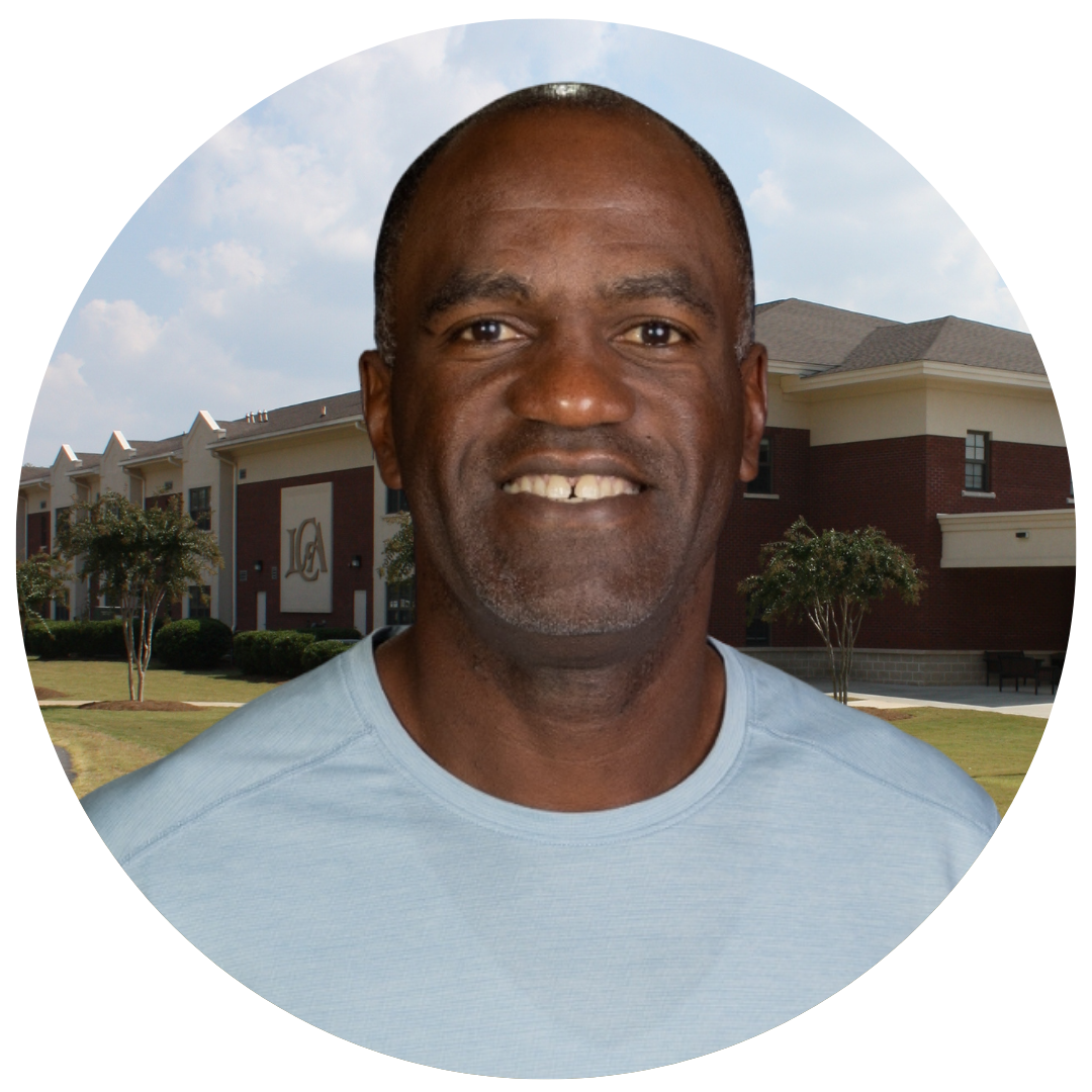 A smiling man in front of a school building