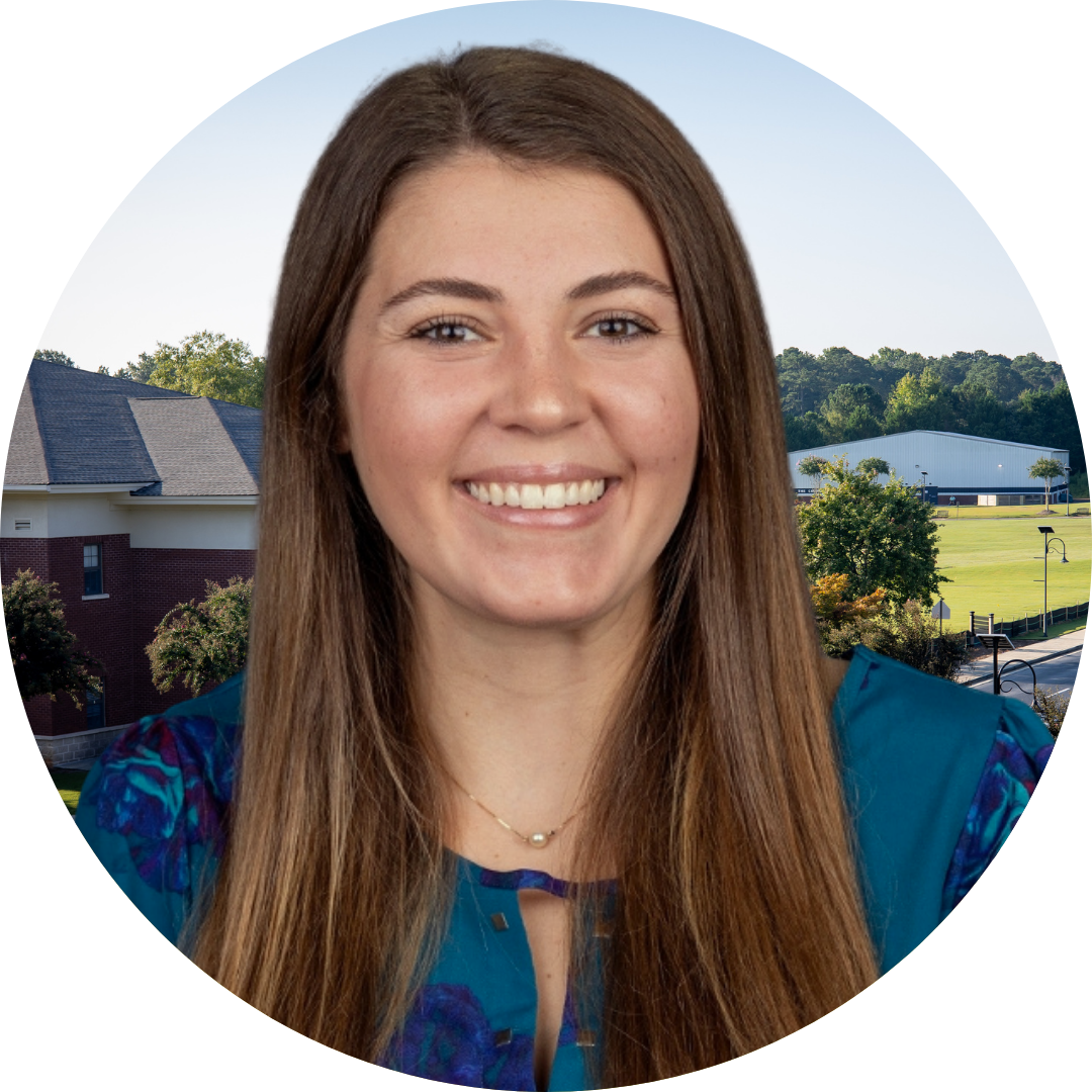 A smiling woman in front of a school building