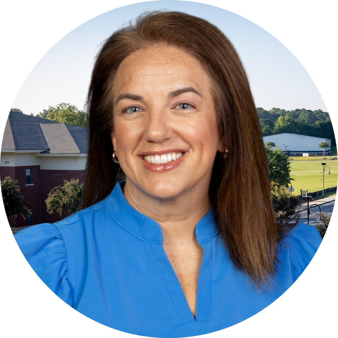 A smiling woman in front of a school building