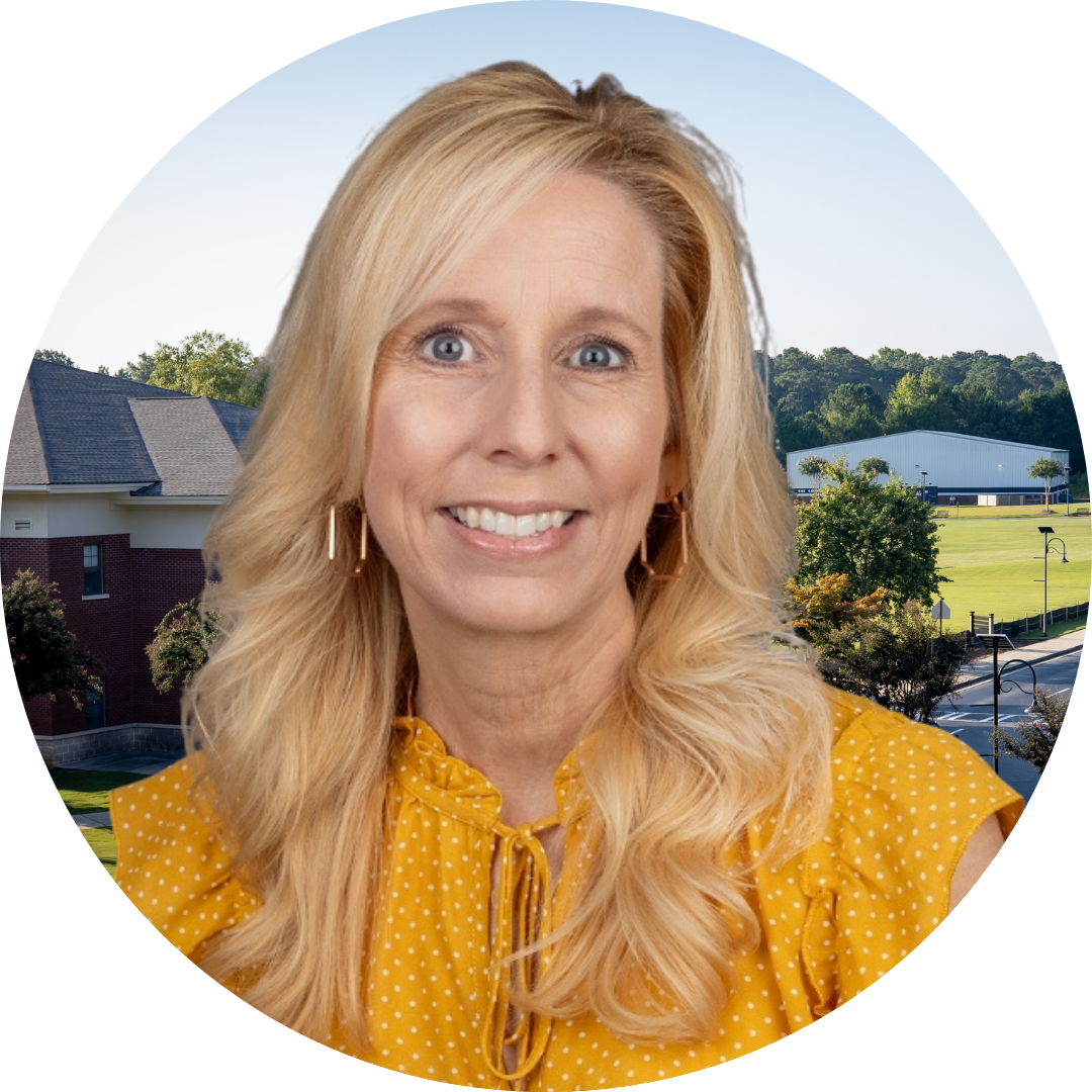 A smiling woman in front of a school building