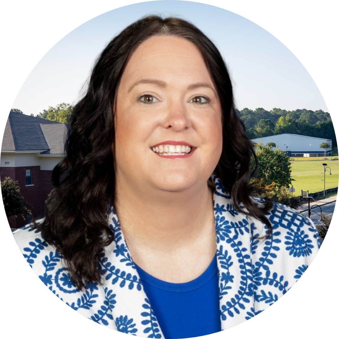 A smiling woman in front of a school building