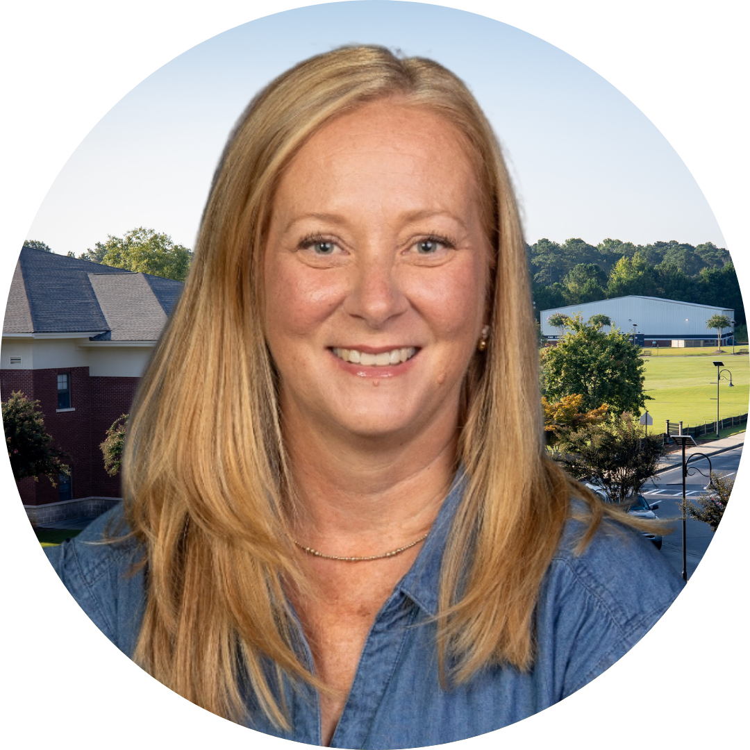 A smiling woman in front of a school building