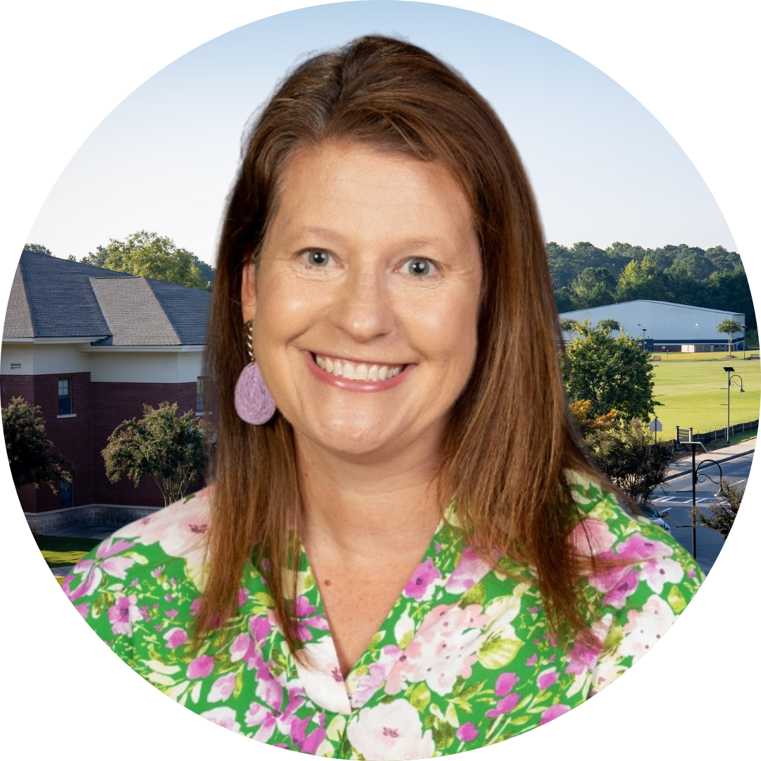 A smiling woman in front of a school building