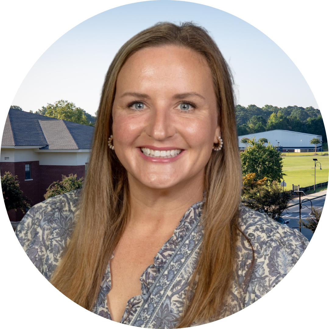 A smiling woman in front of a school building