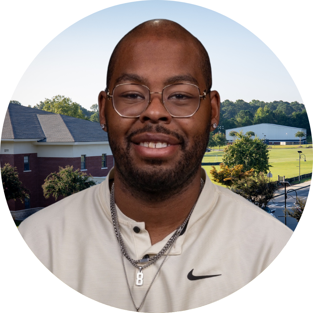 A smiling man in front of a school building