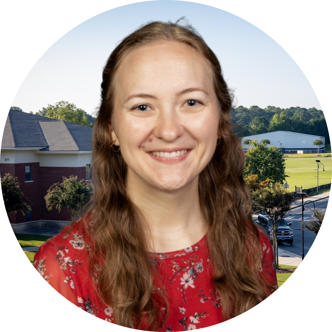 A smiling woman in front of a school building