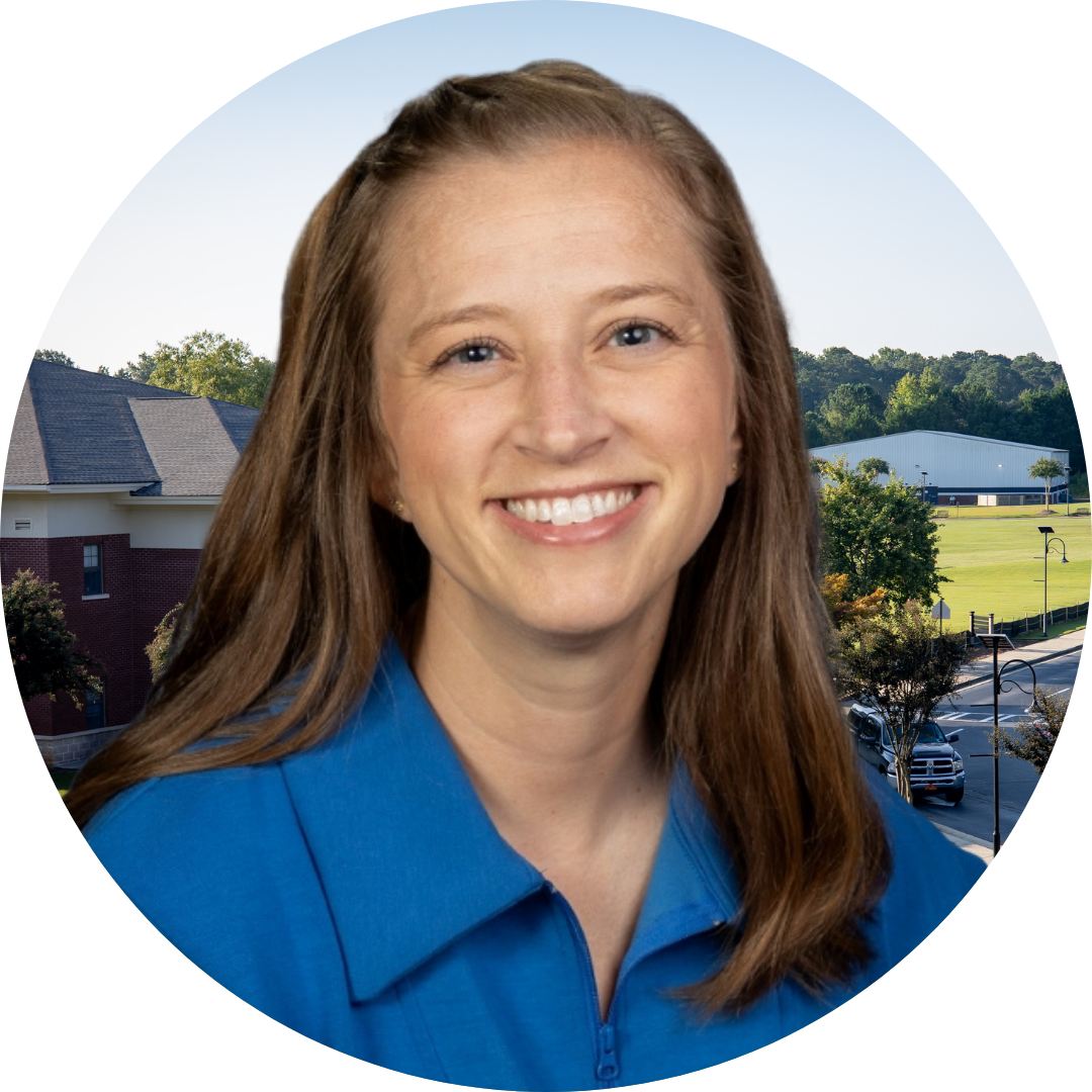 A smiling woman in front of a school building