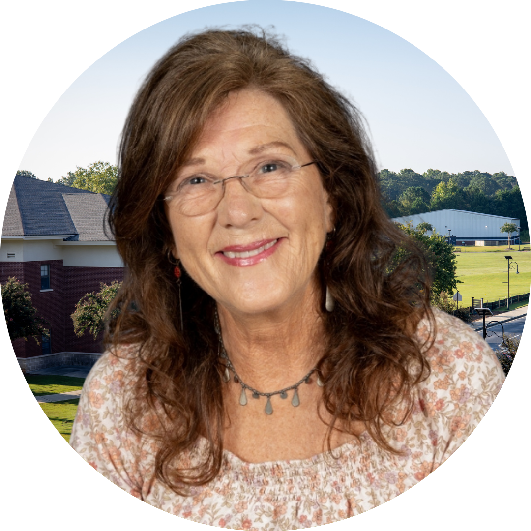 A smiling woman in front of a school building