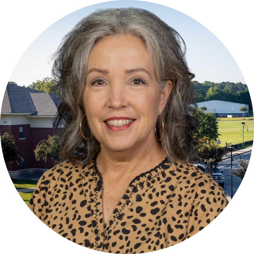 A smiling woman in front of a school building
