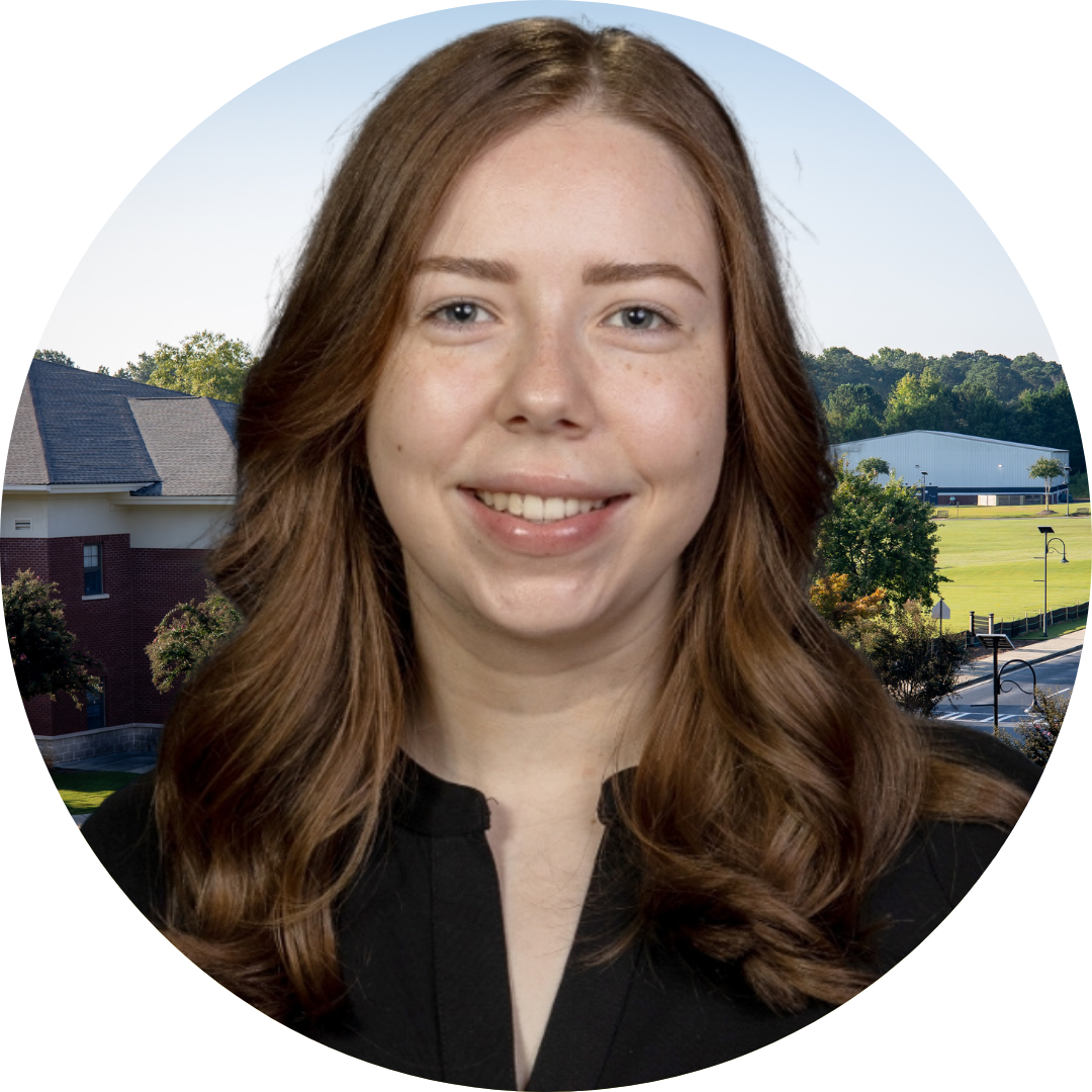 A smiling woman in front of a school building