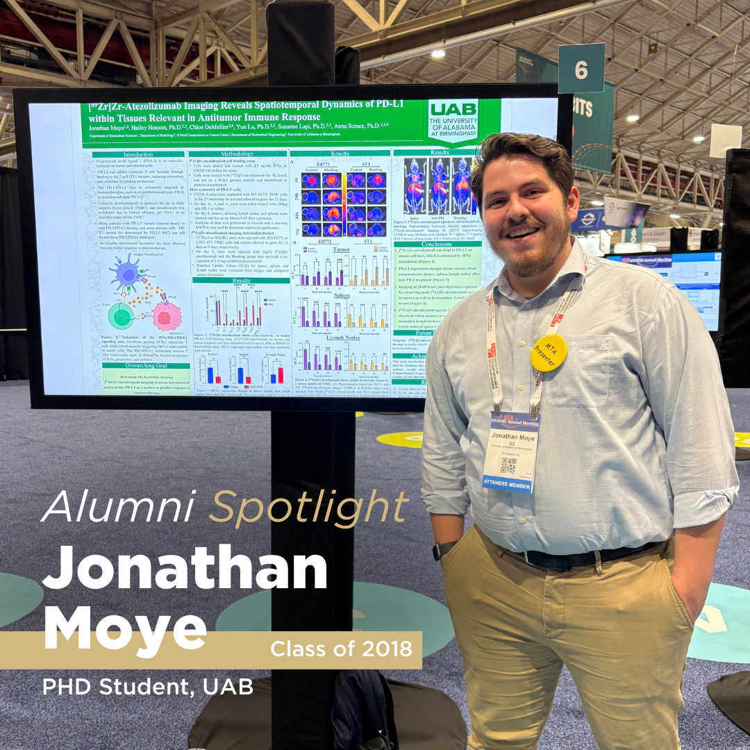 A black haired man poses for a photo smiling next to his research findings for his PhD program, featuring him in an alumni spotlight blog post.